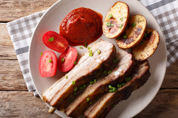 istock Fried pork ribs with sauce and tomatoes on close up. horizontal top view 1036809936