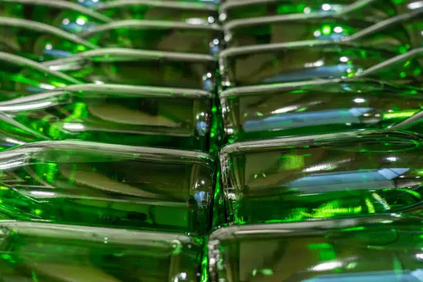 Green wine bottles filled with white wine stacked on top of each others