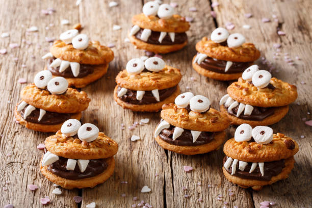 istock Heloween dessert: funny monsters made of biscuits with chocolate and marshmelow close-up. horizontal 1036813110