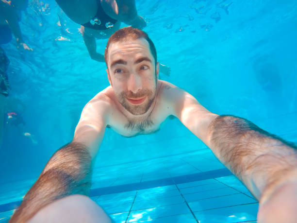 istock Young handsome man diving underwater in a swimming pool 1036814974