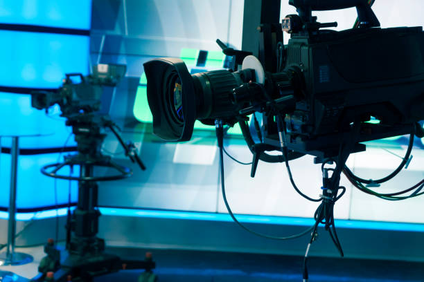 istock Broadcast television studio camera and crane camera in news studio room with LED lights 1036815002