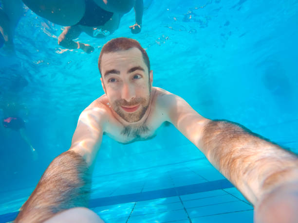 istock Young handsome man diving underwater in a swimming pool 1036815012