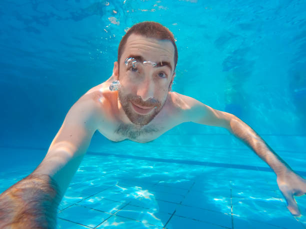 istock Young handsome man diving underwater in a swimming pool 1036815310
