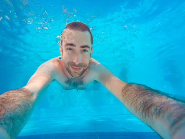 istock Young handsome man diving underwater in a swimming pool 1036815408
