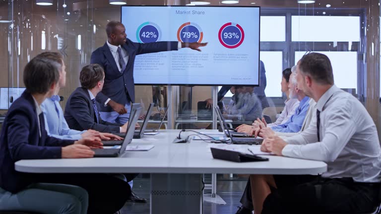 DS African business man holding a presentation using the display in the glass conference room