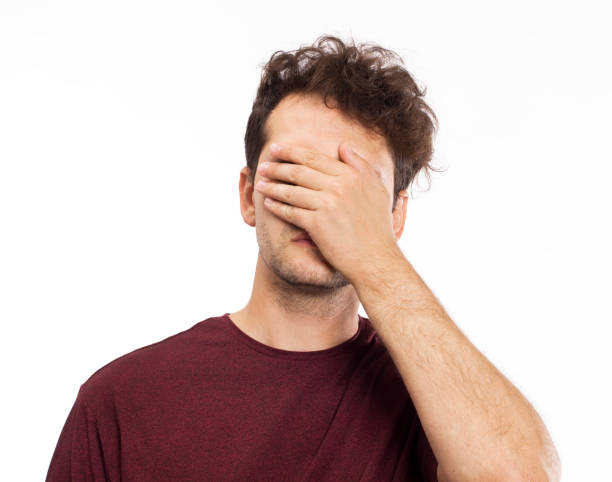 istock Man in depression covering his eyes by hands 1036832082
