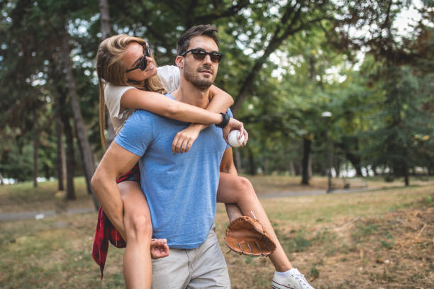 istock Cute couple spending time together in a forest playing baseball 1036848740
