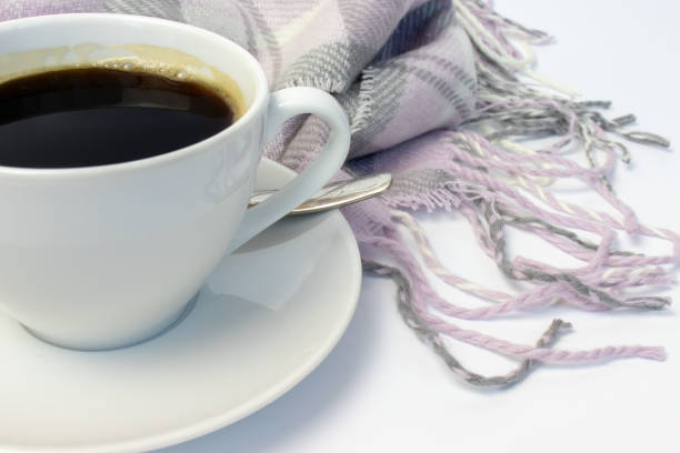 istock White ceramic cup of coffee and pink knitted plaid on white 1036860428