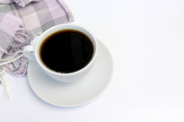 istock White ceramic cup of coffee and pink knitted plaid on white with copy space 1036860556