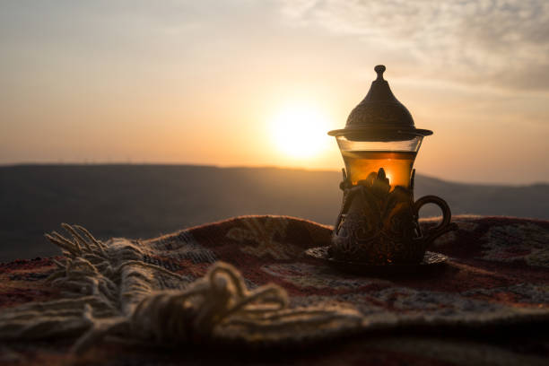 istock Arabian tea in glass on a eastern carpet. Eastern tea concept. Armudu traditional cup. Sunset background. Selective focus 1036863306
