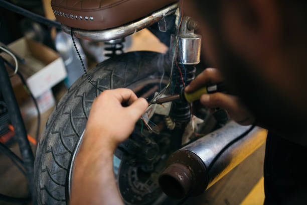 istock Man fixing electric wires on custom bike 1036870928