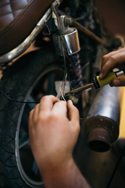 istock Man fixing electric wires on custom bike 1036871296