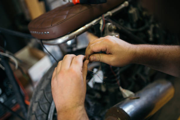 istock Man fixing electric wires on custom bike 1036871544