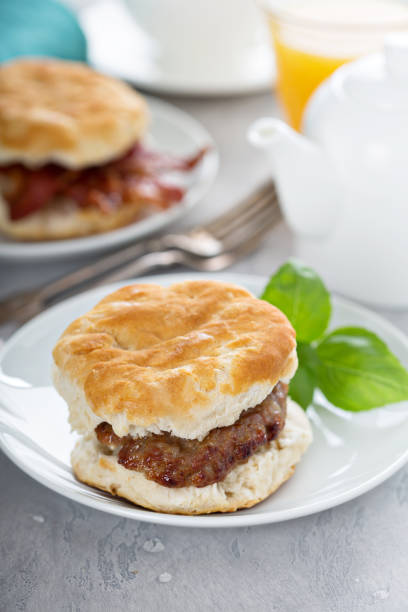 biscuits petit déjeuner avec des saucisses et bacon - biscuit au babeurre photos et images de collection