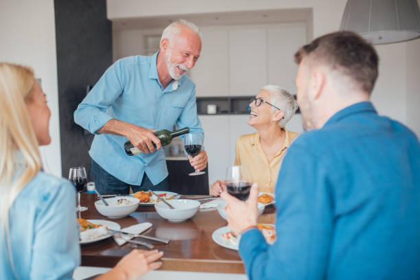 istock Smiling old man pouring red wine 1036881842