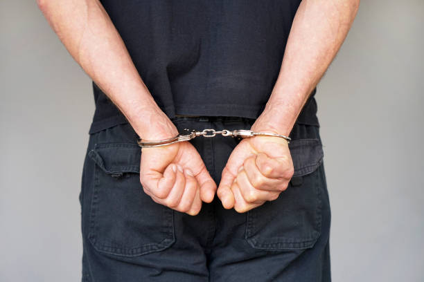 istock Criminal hands locked in handcuffs. Close-up view 1036886502