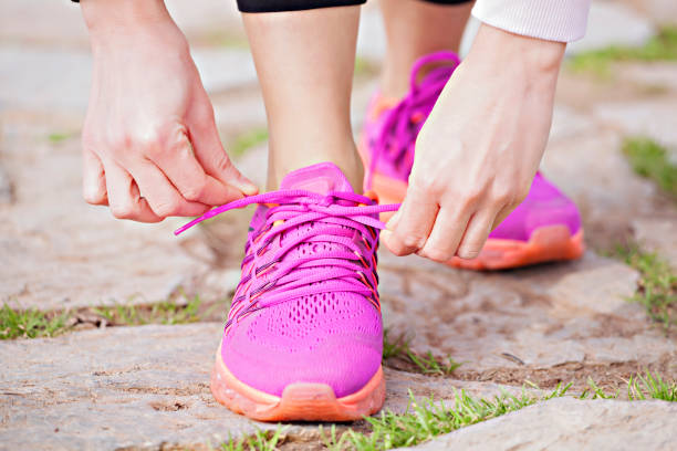 istock Young woman runner tying shoelaces 1036887154