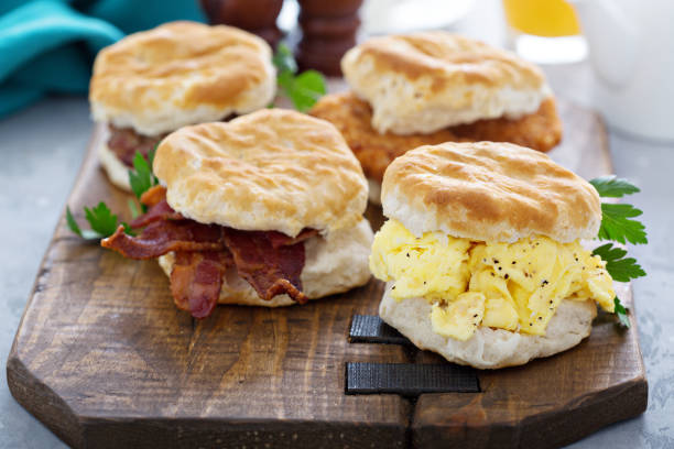 biscotti per la colazione con uova strapazzate morbide e pancetta - sandwich eggs bacon breakfast foto e immagini stock