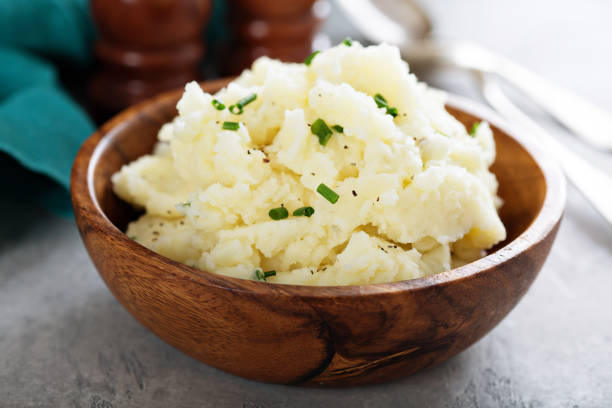 Fluffy mashed potatoes with chives Fluffy mashed potatoes with chives in a wooden bowl mashed potatoes stock pictures, royalty-free photos & images