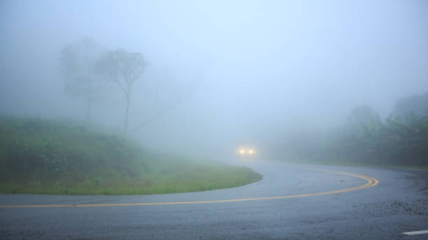 istock Foggy road on the mountain with a car in background 1036896072