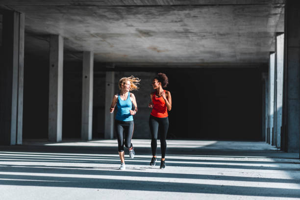 istock Two female athletes running together 1036911758