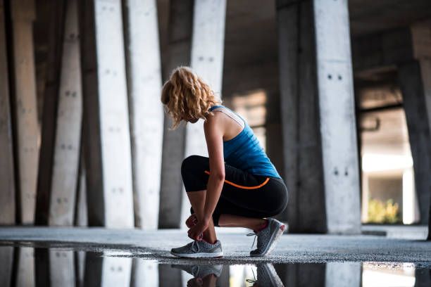 istock Woman athlete tying her shoe 1036911786