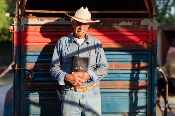 istock Senior mexican man standing and holding Bible 1036920646