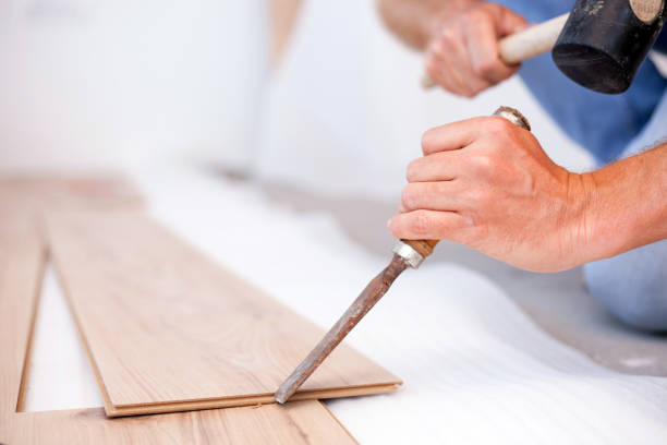 istock Young man chiseling grooves on a laminate floor tile, installing laminate flooring 1036925006