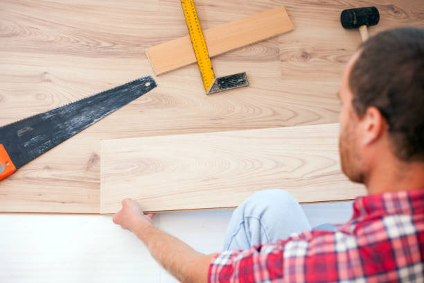 istock Young man installing laminate flooring in new apartment or house. High angle view 1036925214