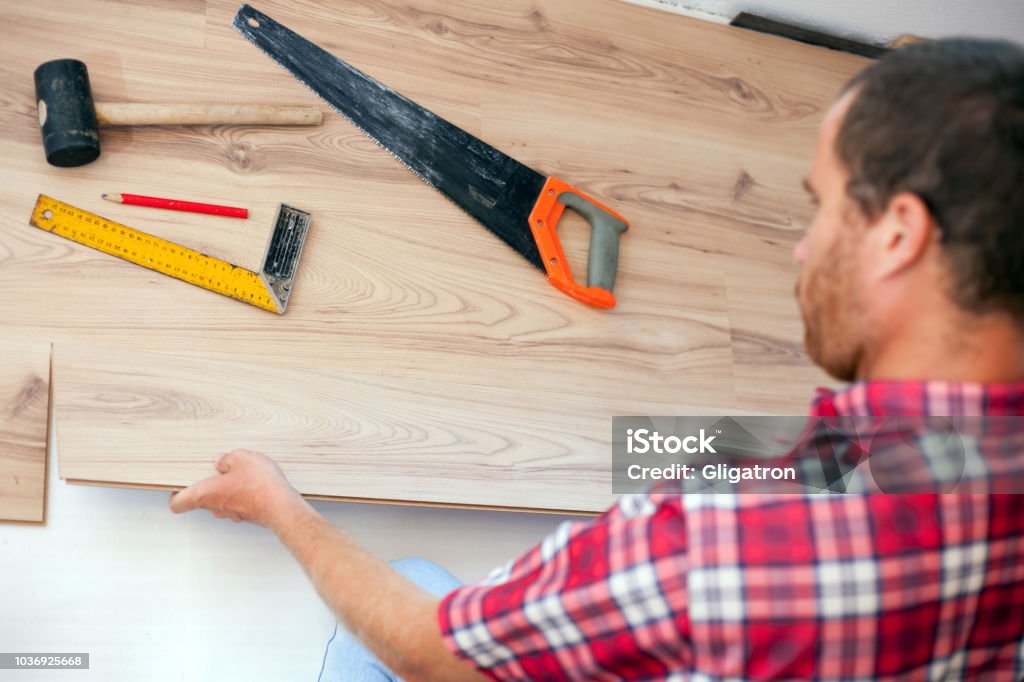 Young man installing laminate flooring in new apartment or house. High angle view Young man installing laminate flooring in new apartment or house. High angle view. Home improvement and renovation concept 30-39 Years Stock Photo