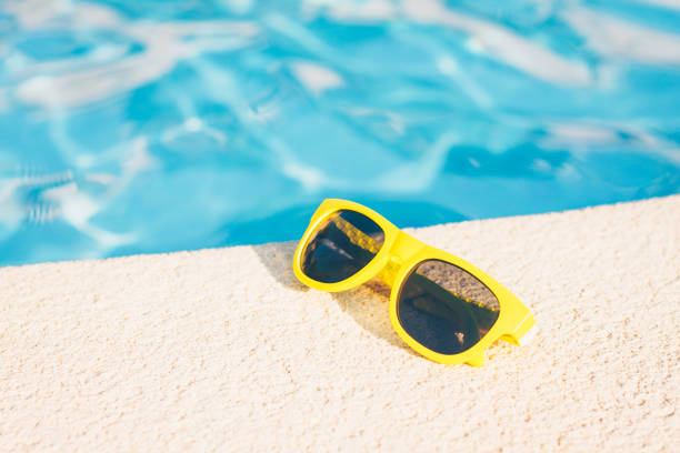 istock sunglasses lying around pool - tropical vacation 1036949048