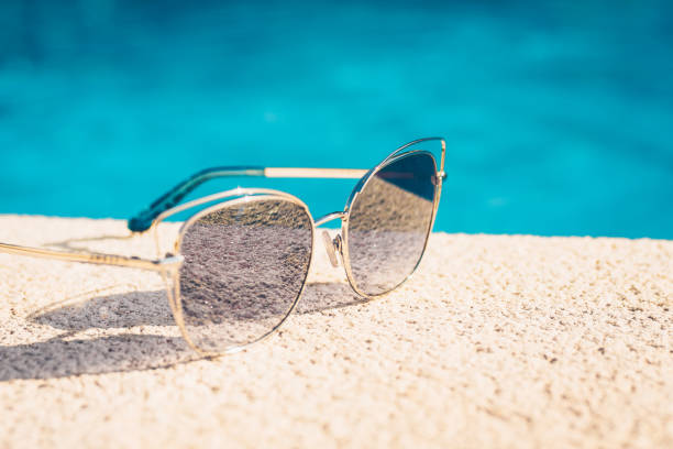 istock sunglasses lying around pool - tropical vacation 1036949066