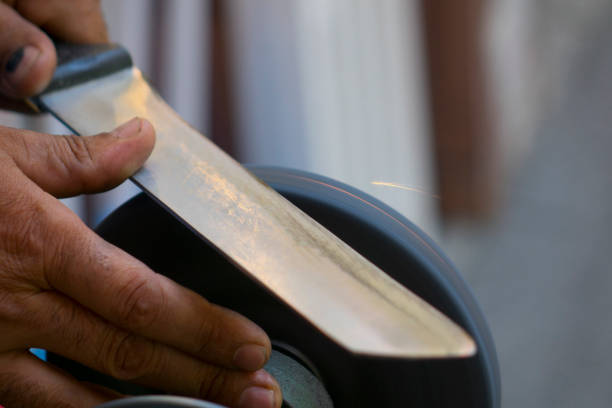 60 Year Old Woman Sharpening Knife With Her Left Hand on The Patio
