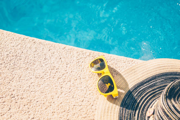 istock Sunglasses and hat on the poolside - girl on vacation 1036955472