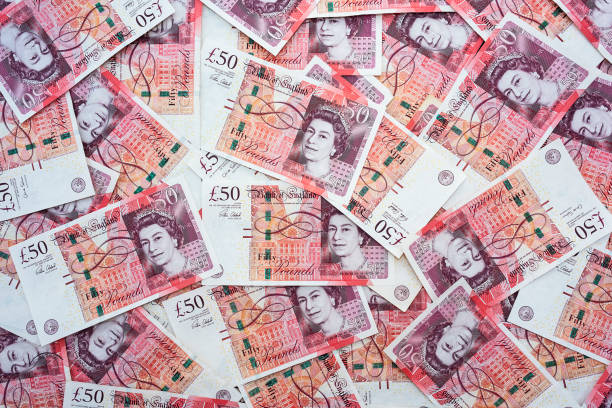 Spread of random 50 British Pound notes stock photo