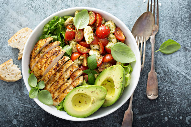 Caprese lunch bowl with grilled chicken Caprese lunch bowl with grilled chicken and avocado lime basil plant stock pictures, royalty-free photos & images