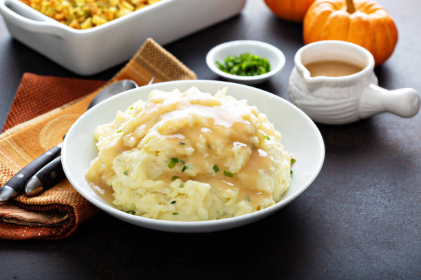 Mashed potatoes with gravy for Thanksgiving Mashed potatoes with gravy, traditional side dish for Thanksgiving mashed potatoes stock pictures, royalty-free photos & images
