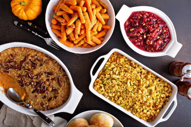 All traditional Thanksgiving side dishes, roasted carrots, sweet potato casserole, cranberry sauce and stuffing