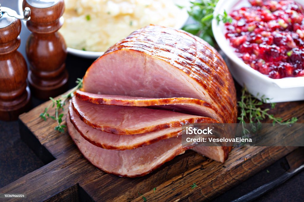 Holiday glazed sliced ham Holiday glazed sliced ham on dinner table for Thanksgiving or Christmas Ham Stock Photo