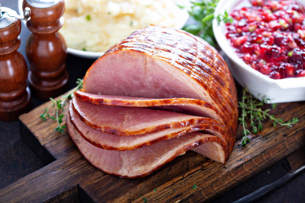 Holiday glazed sliced ham Holiday glazed sliced ham on dinner table for Thanksgiving or Christmas smoked food stock pictures, royalty-free photos & images