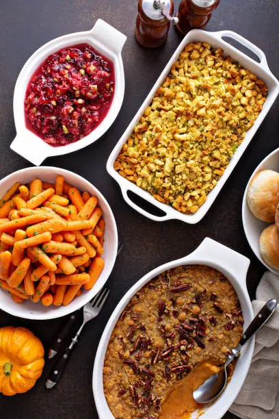 All traditional Thanksgiving side dishes, roasted carrots, sweet potato casserole, cranberry sauce and stuffing