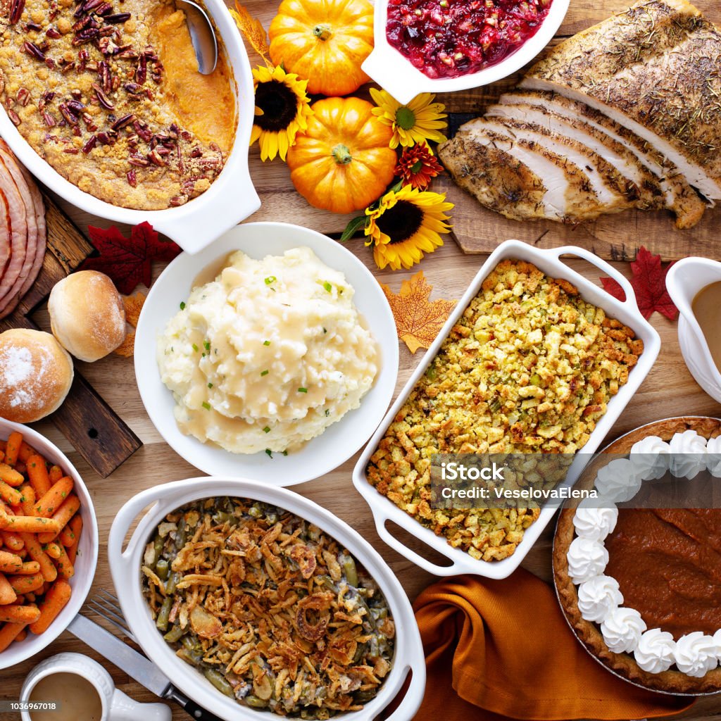 Thanksgiving table with turkey and sides Thanksgiving table with roasted turkey, sliced ham and side dishes Thanksgiving - Holiday Stock Photo