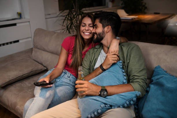 istock Couple sitting on sofa and watching television 1036984206