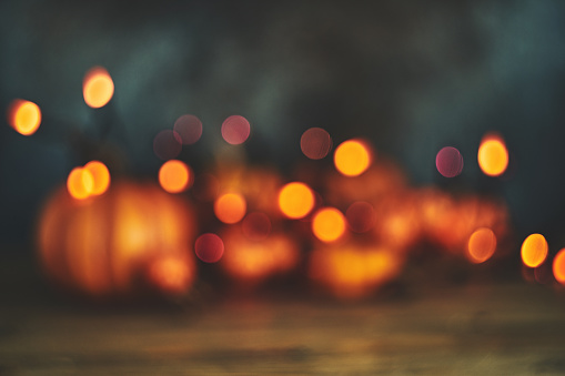 Defocused background with pumpkins and string lights for Halloween or Thanksgiving