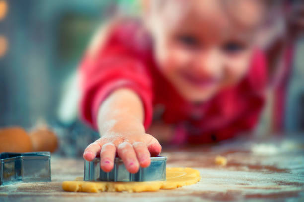 little girl preparing christmas biscuits - pastry cutter family holiday child imagens e fotografias de stock