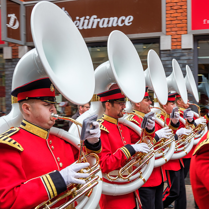 Marching band with five sousaphone blazers neatly lined up in a row marching through the streets of Delft, the Netherlands