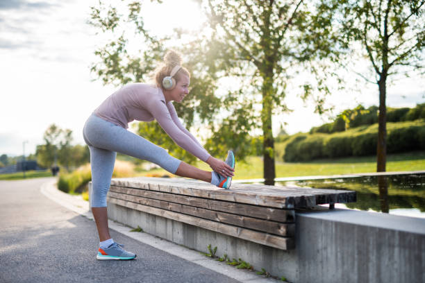 Young sport woman stretching before running in park.