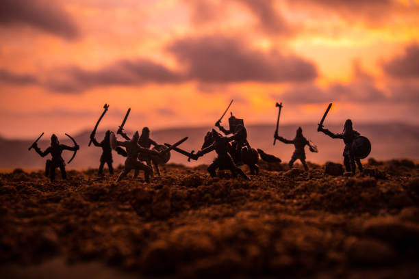 istock Medieval battle scene with cavalry and infantry. Silhouettes of figures as separate objects, fight between warriors on sunset foggy background. 1037014128