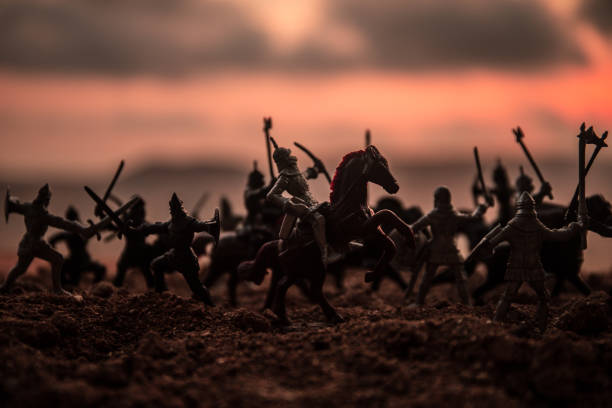 istock Medieval battle scene with cavalry and infantry. Silhouettes of figures as separate objects, fight between warriors on sunset foggy background. 1037014132