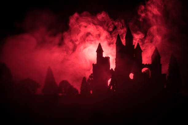 Mysterious medieval castle in a misty full moon. Abandoned gothic style old castle at night. Selective focus